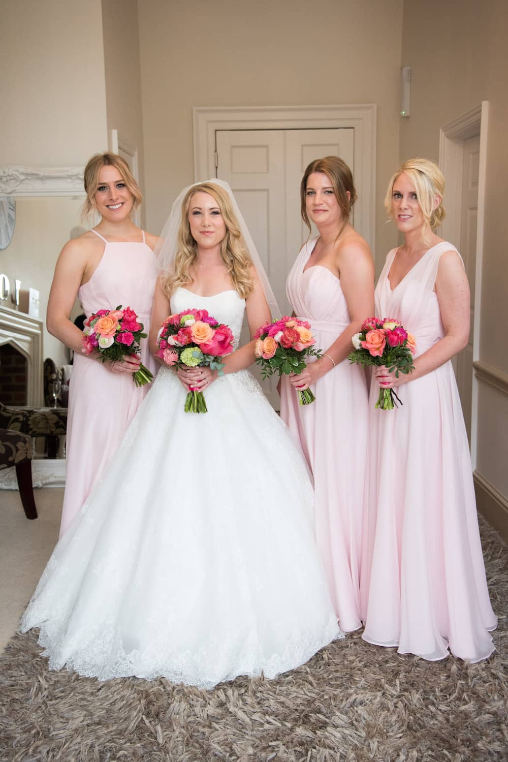 peach, coral and pink bouquets with blush bridesmaids dresses