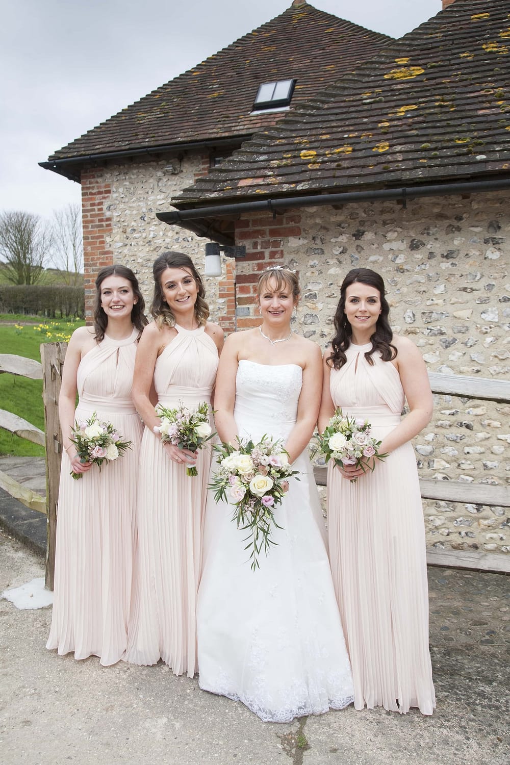 Pangdean barn April wedding. Bride and bridesmaids in nude blush pink dresses with pink and white flowers