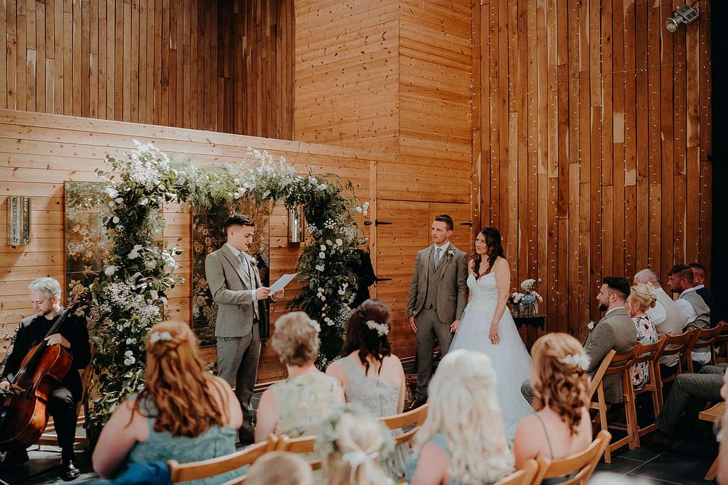 wedding at chafford park estate with wooden walls, bride and groom are standing for their vows