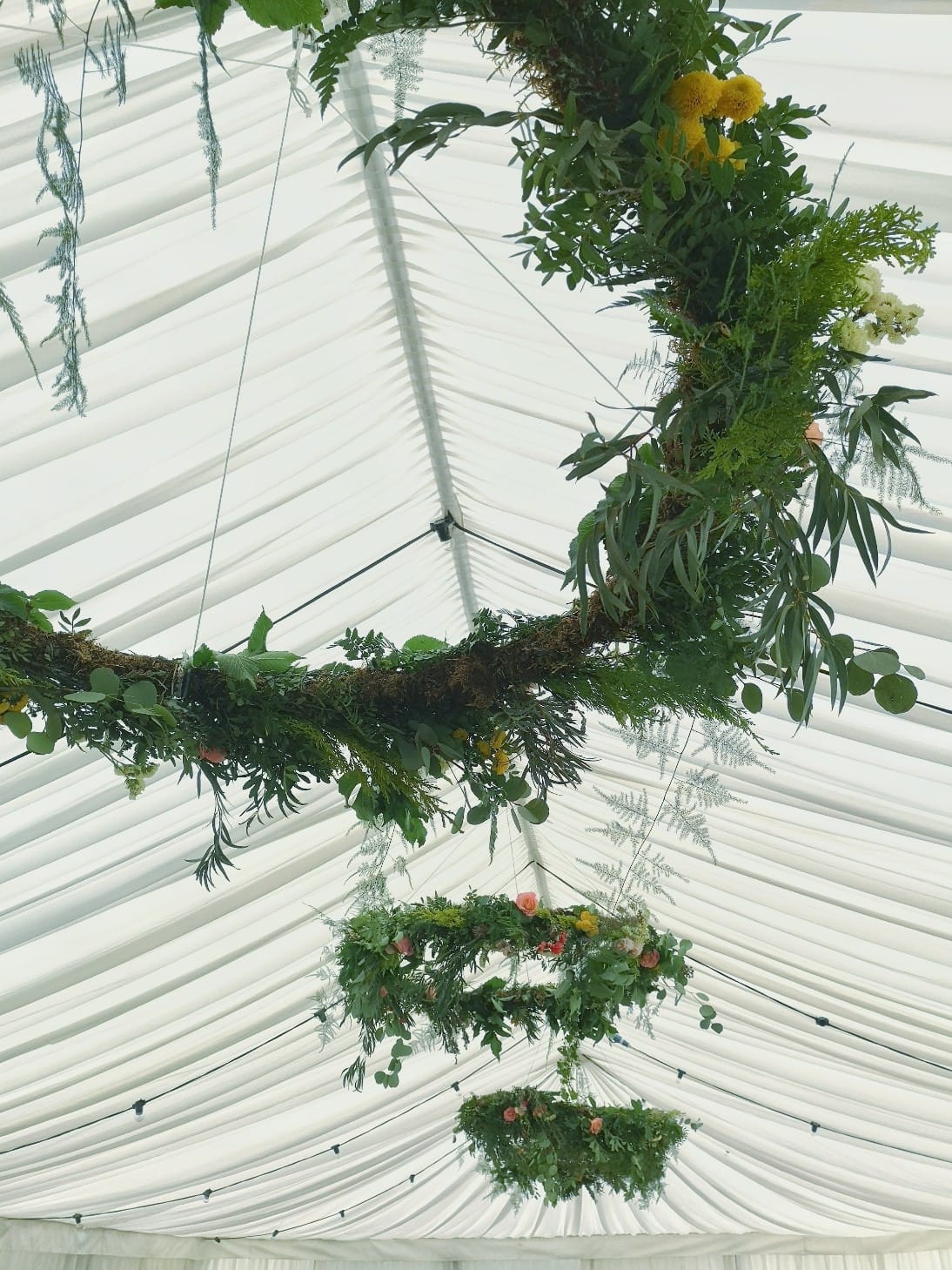 hanging foliage hoops in a wedding marquee