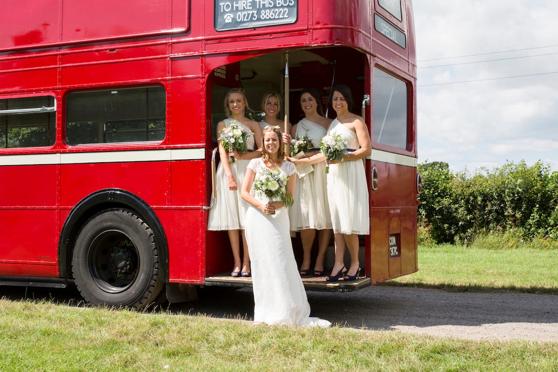 bride and bridesmaids with vintage red bus