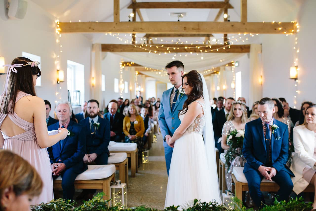 southend barns wedding ceremony with foliage garland and fairy lights
