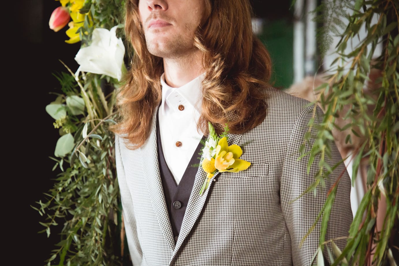 rock n roll groom, long hair and yellow buttonhole