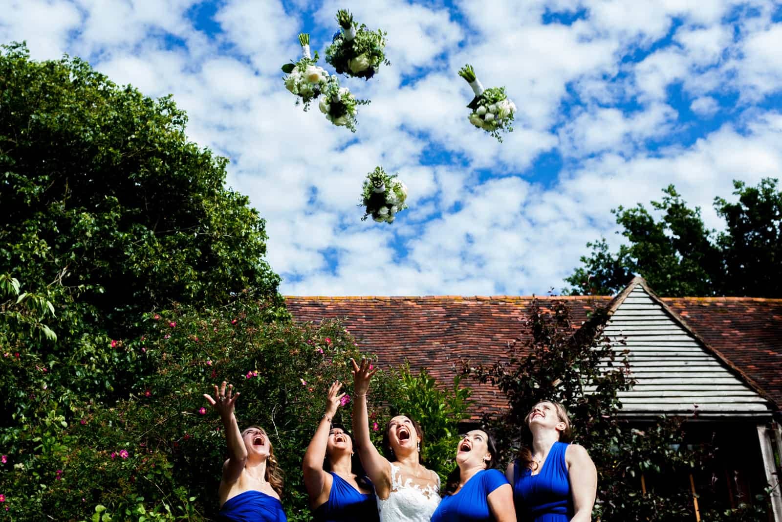 bride and bridesmaids throwing their bouquets in the air at The English Wine Centre