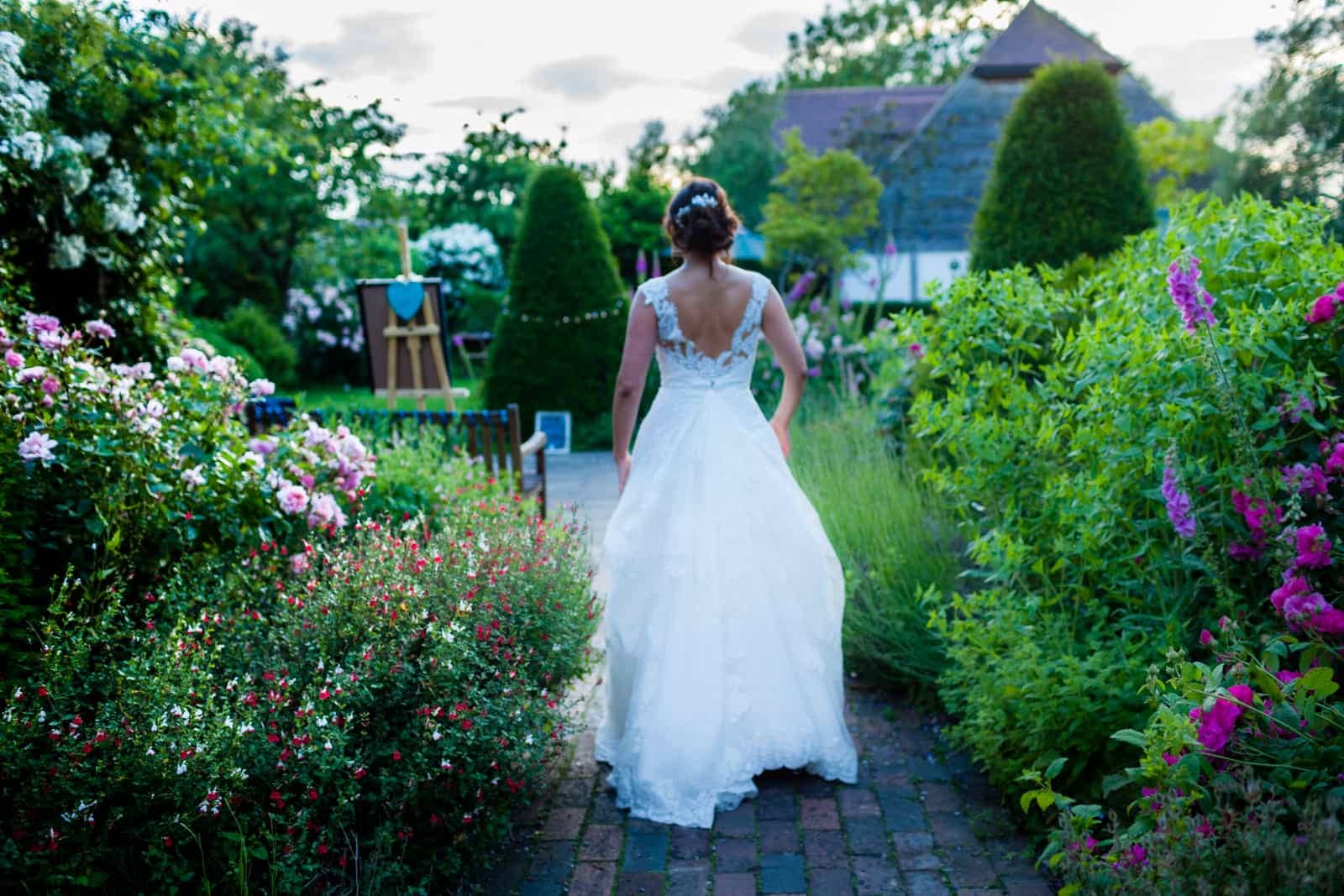 Bride walking through the rose garden at The English Wine Centre