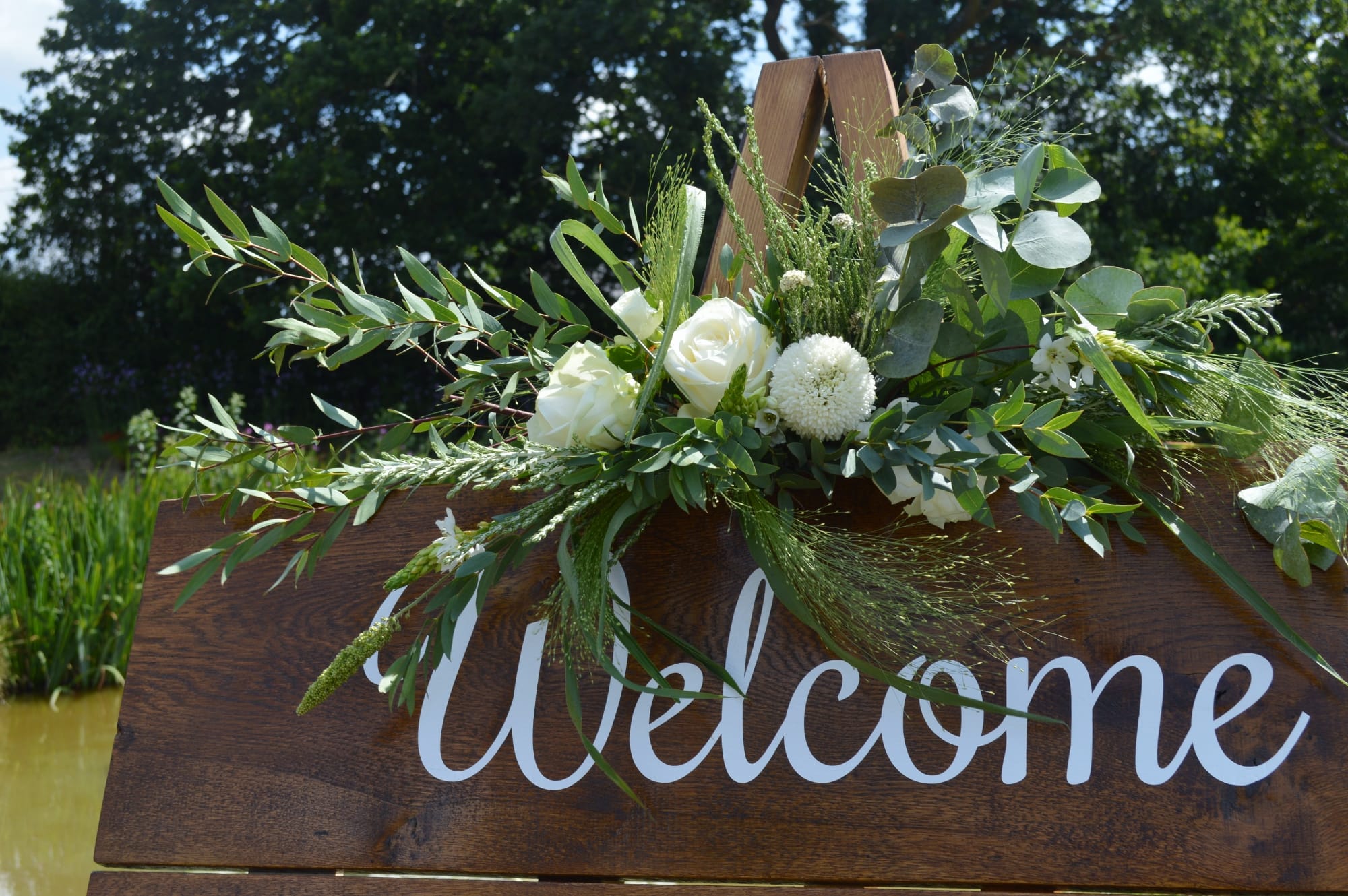 wedding welcome sign with white flowers, succulents and eucalyptus