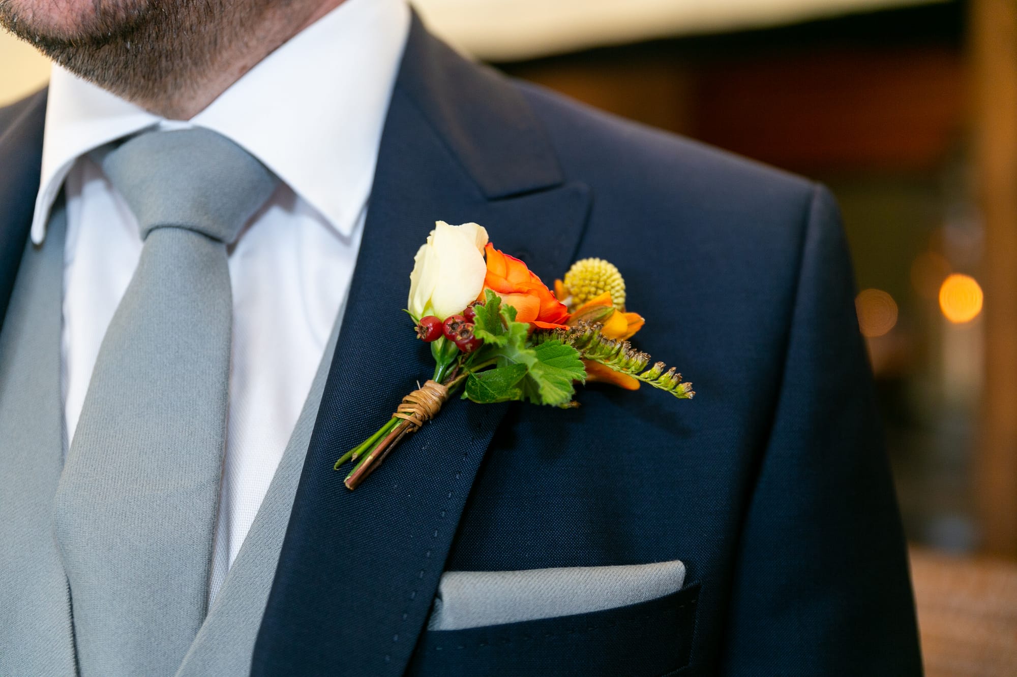 grooms orange and yellow buttonhole at pangdean barn