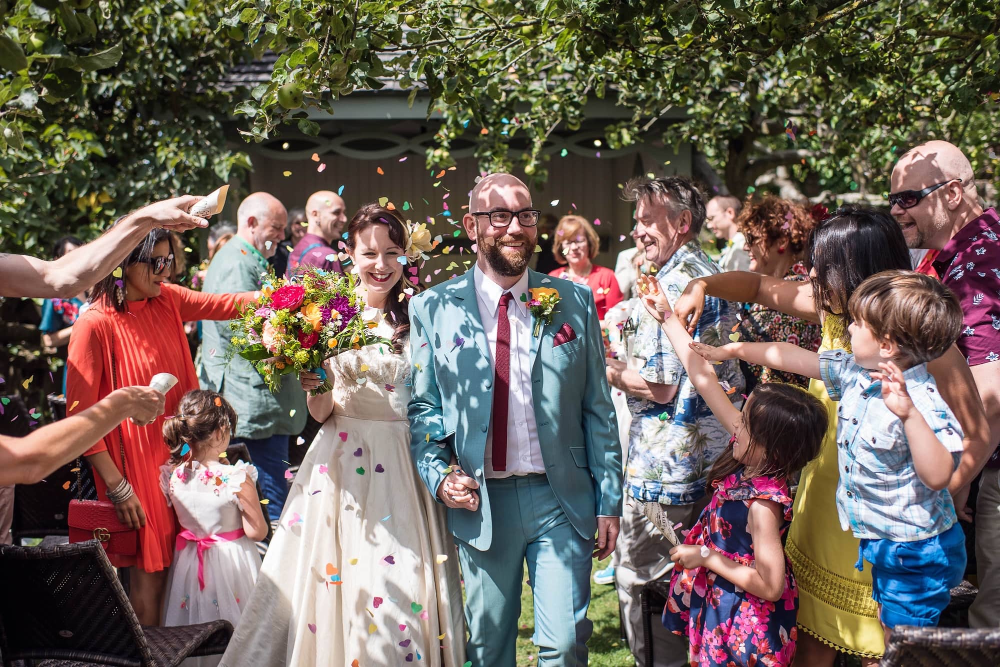 Brighton outdoor wedding, bride and groom with colourful flowers and confetti
