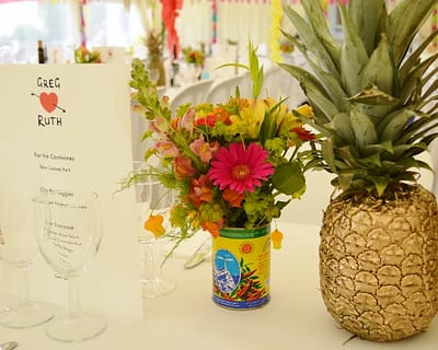 Tropical wedding flowers, gold pineapple table decorations.