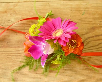 Pink and orange wrist corsage. Tropical wedding flowers. Brighton, Sussex florist