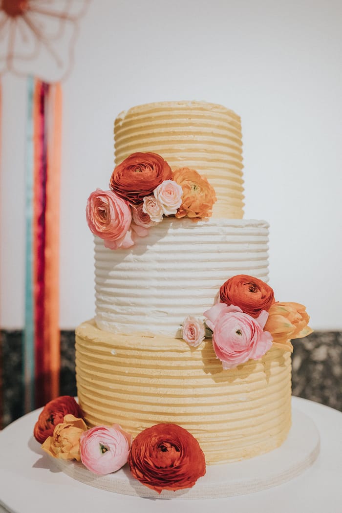 gold cake with blush and red flowers
