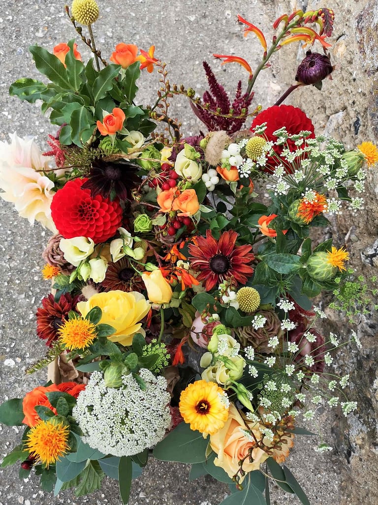 red, yellow, peach and orange flowers for September same sex wedding at pangdean barn