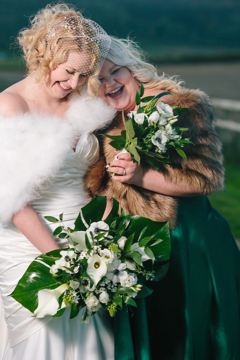 bride and bridesmaids with faux fur coats at long furlong barn sussex