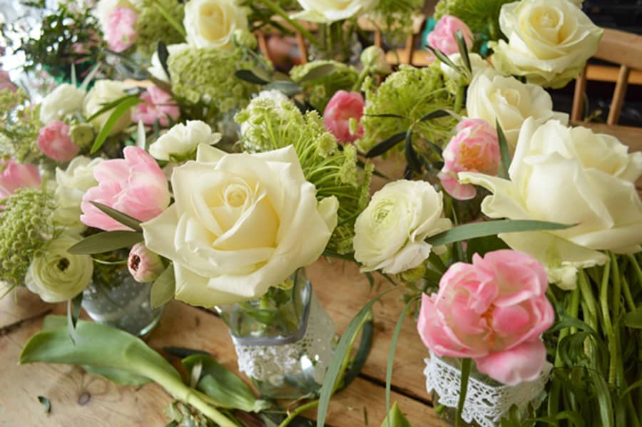 wedding jam jar arrangements with roses and tulips