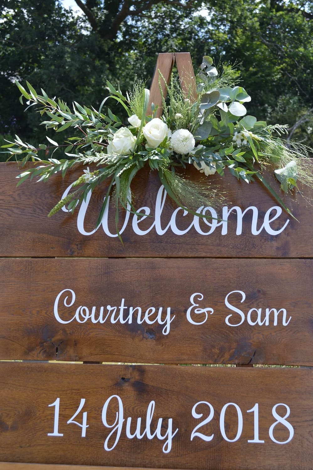 boho wooden welcome sign for wedding with white roses and eucalyptus