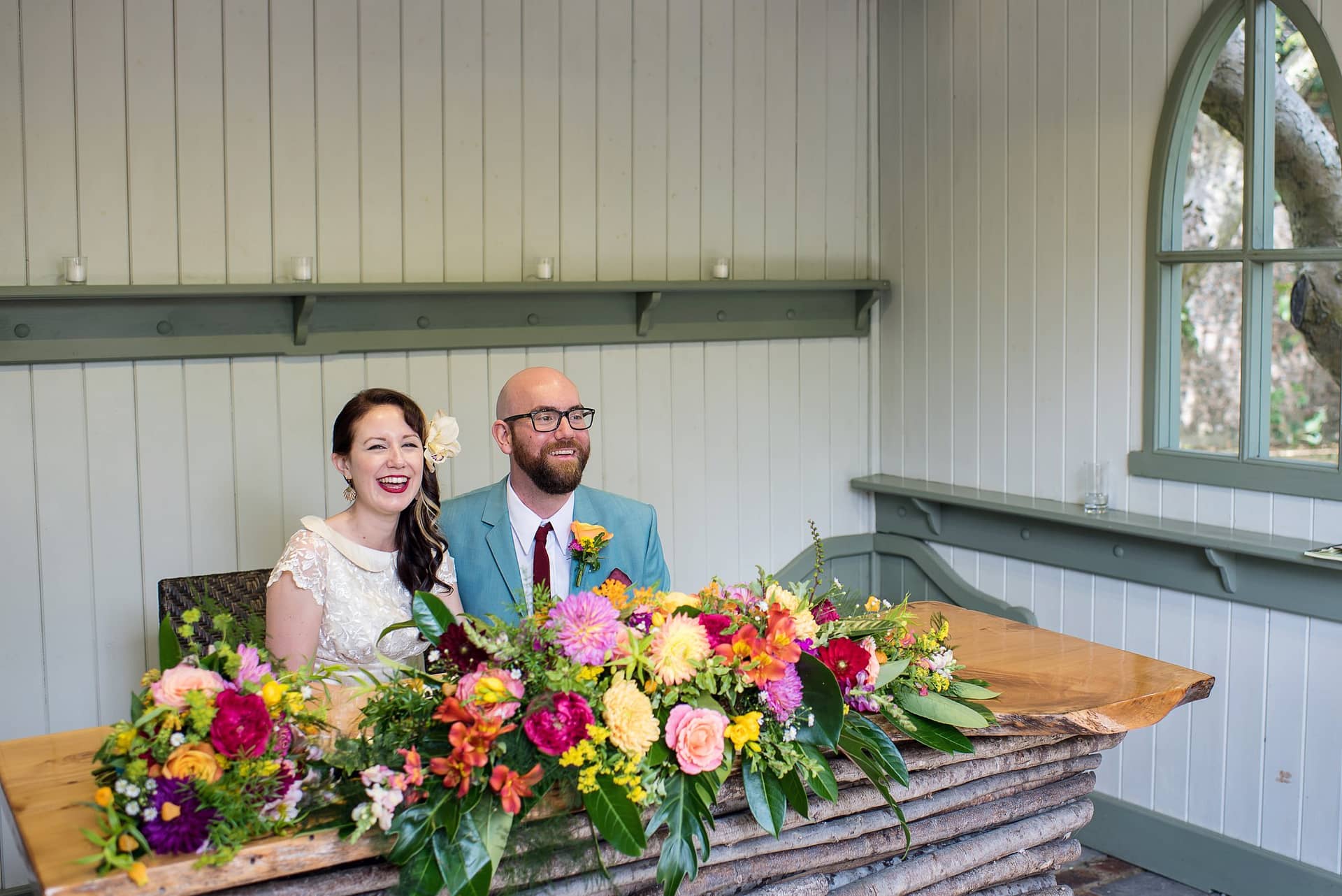 colourful outdoor wedding at Pangdean Barn. Bride and groom with bright flowers