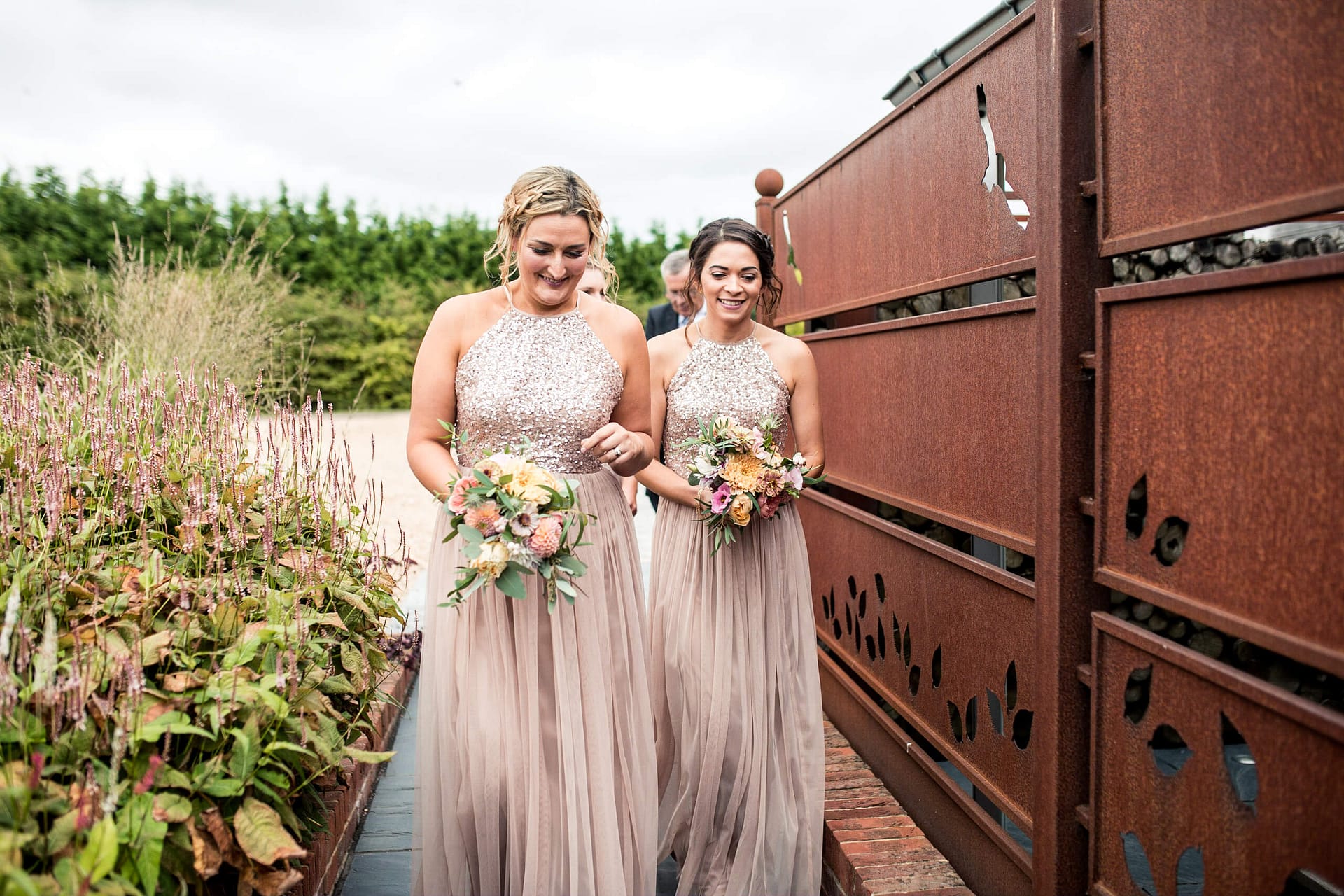 bridesmaids in nude coloured dresses with peach and pink flowers at southend barns 